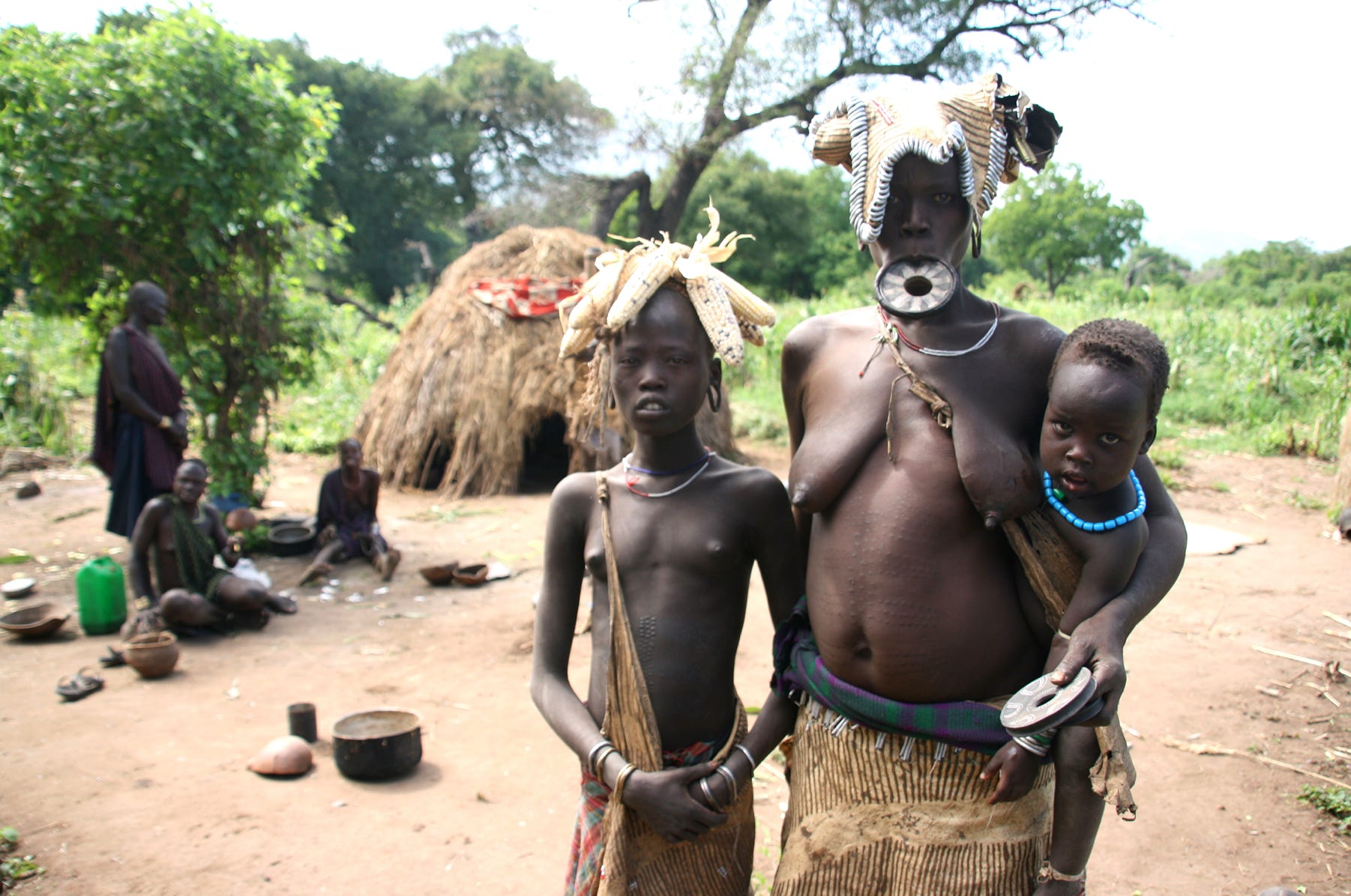 A mother with two of her children in a Mursi settlement in the Omo Valley of Ethiopia.
